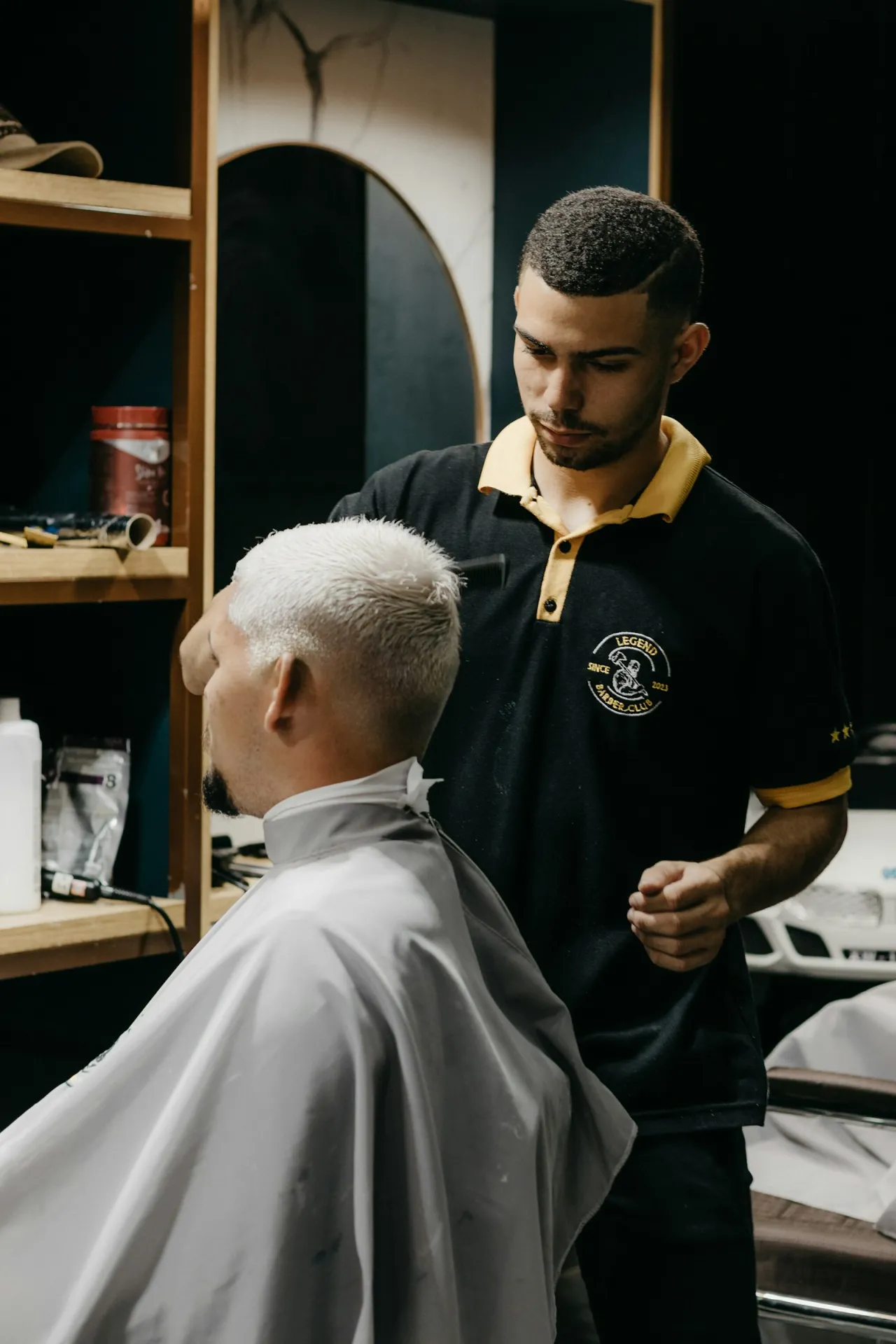 Barbero atendiendo a un cliente de cabello canoso